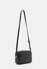 Černá texturovaná crossbody taška se zipovým uzávěrem, obdélníkový tvar, štíhlý nastavitelný popruh a akcenty zlatého kovu.