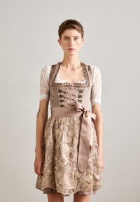 Robe dirndl traditionnelle avec des manches en dentelle crème, broderies florales complexes en or et beige, et un nœud en satin à la taille.