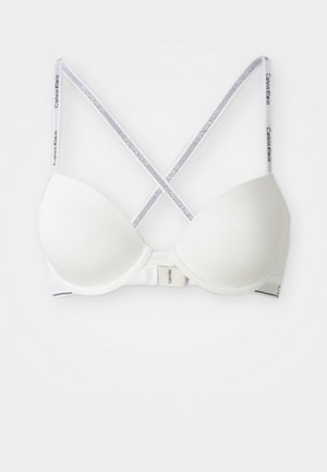 Soutien-gorge rembourré blanc avec des bretelles croisées à la marque Calvin Klein et une fermeture à crochet au dos, sur fond blanc.