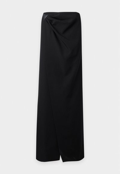 Longue robe noire bustier avec un détail drapé et un petit ornement triangulaire près du haut côté gauche.