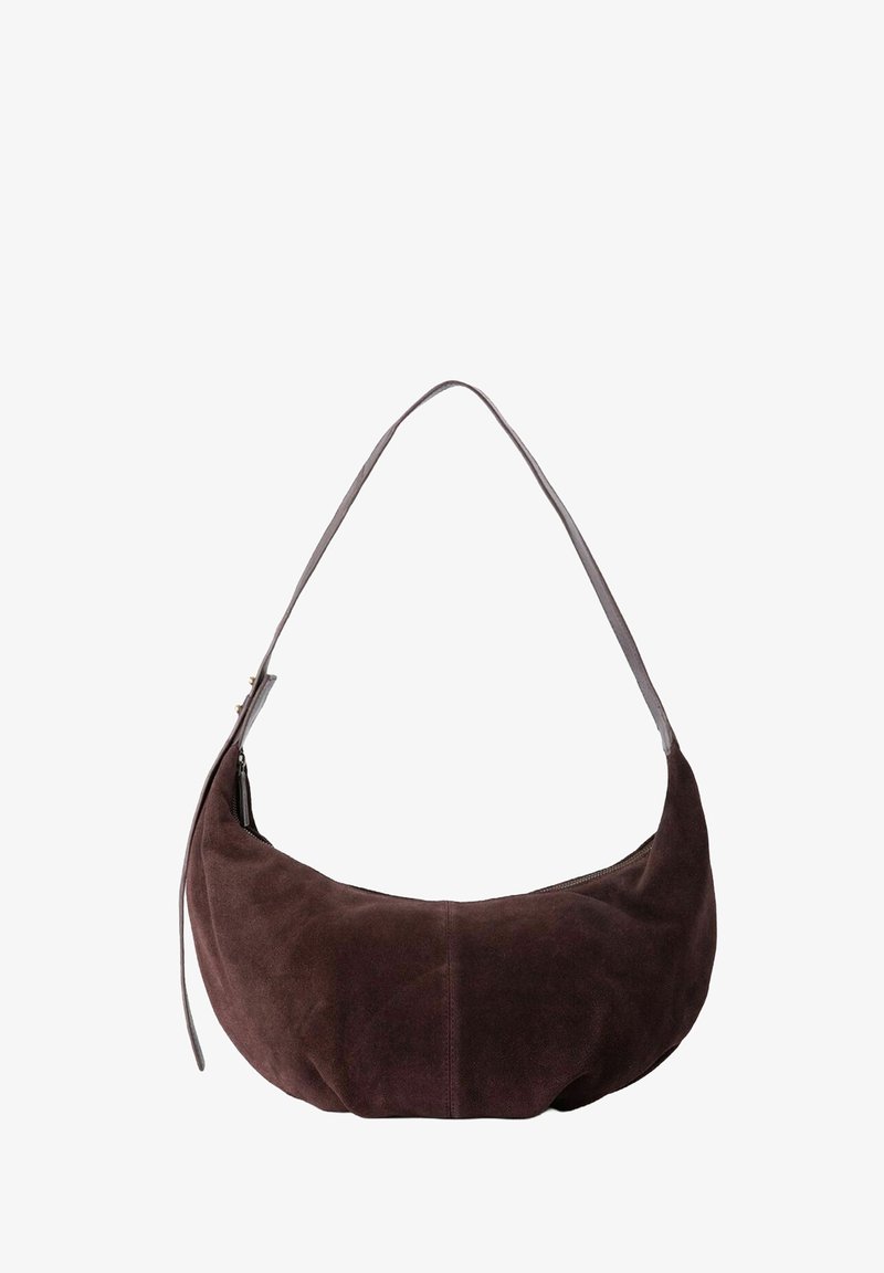 Sac hobo en daim marron foncé, avec une forme courbée, une longue bandoulière et un détail de fermeture éclair sur un côté. Texture lisse avec un subtil éclat.
