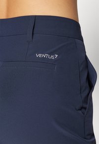 Tengerészkék rövidnadrág sima textúrával, hátsó zsebbel és fehér "VENTUS 7" hímzéssel a jobb hátsó részen.