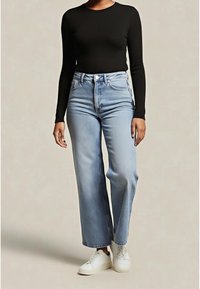 Černý top s dlouhým rukávem ve svobodném střihu, doplněný světlými modrými širokými džíny s vysokým pasem a bílými teniskami; ležérní styl s pohodlným střihem.