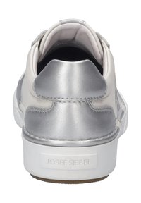 Stříbrná kožená teniska s hladkým povrchem, bílá gumová podrážka a embossované jméno značky. Ohnutý tvar s polstrovaným límcem.