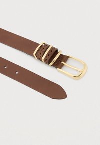 Cinto de couro castanho com fivela dourada polida, apresentando detalhes perfurados e múltiplos furos de ajuste. Textura lisa e extremidade afunilada.