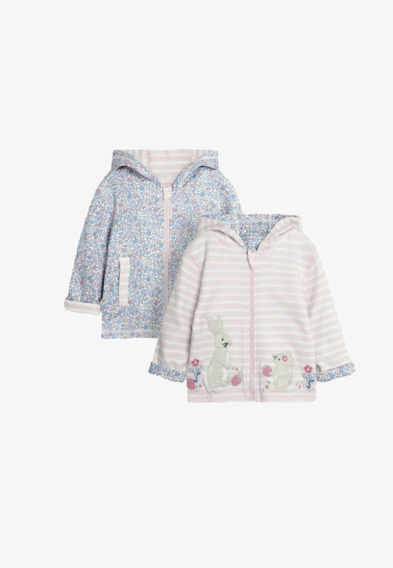 Na displeji sú dve detské bundy s kapucňou. Jedna má kvetinový motív v modro-bielej farbe; druhá je ružová s pruhovaným vzorom a výšivkou zvierat.