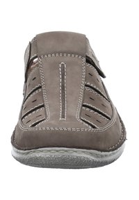 Graue Wildlederschlupfschuhe mit Ausschnitten, doppeltem Riemen und weißen Nähten. Texturiertes Sohlenprofil mit leichter Krümmung. Verstärkter Zehenbereich.