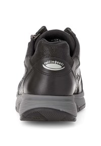 Chaussure de sport en cuir noir avec un col rembourré, semelle grise et logo à l'arrière. Design minimaliste avec des accents texturés et une structure de soutien.