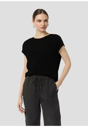 Black short-sleeve top in a soft fabric, featuring a crew neckline and subtle detail at the shoulders, paired with loose grey pants.