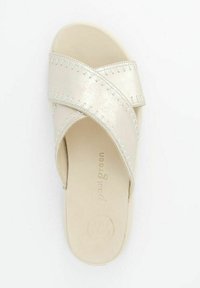 Metaalbeige slipper met kruislings overlappende banden, voorzien van gestikte accenten en een zachte loopzool. Merkenlogo zichtbaar op de binnenzool.
