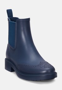 Bottines Chelsea bleu marine en caoutchouc, avec des panneaux latéraux élastiques, des détails perforés, un bout arrondi et un petit talon carré.