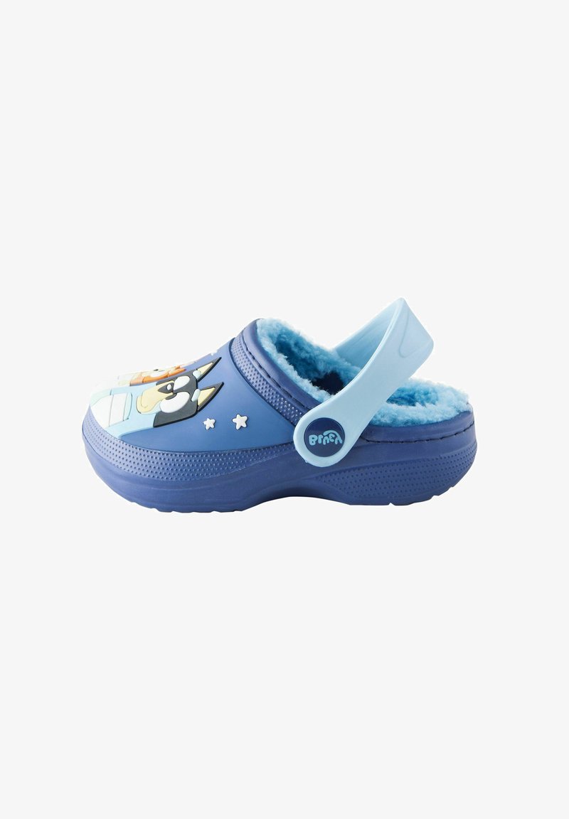 Zoccolo blu con morbida fodera interna, caratterizzato da una grafica di animali cartoon, cinturino regolabile, superficie testurizzata e accenti a forma di stella sui lati.