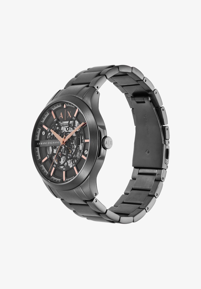 Schwarze automatische Herrenuhr von Armani Exchange mit roségoldfarbenen Zeigern und Markierungen, skelettiertem Zifferblatt und Metallgliederarmband.