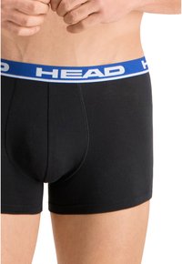 Boxer-briefs noirs avec une ceinture bleue arborant le mot "HEAD" bien en évidence. Texture lisse, design ajusté et couture sans coutures.