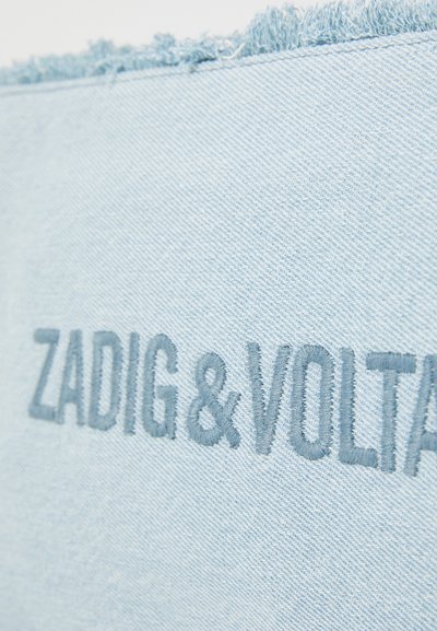 Lichtblauwe denimstof met rafelige randen, voorzien van gebordurde tekst "ZADIG & VOLTAIRE" in een iets donkerdere blauwe draad.
