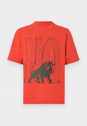 Punane lühikeste varrukatega T-särk, mille ees on suur must "EI" tekst ja must härja graafika, mis seisab tähtede ees.