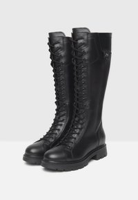 Bottes noires en cuir haute jusqu'au genou avec un laçage à l'avant, semelle en caoutchouc robuste et un détail de logo subtil sur le dessus. Texture lisse partout.