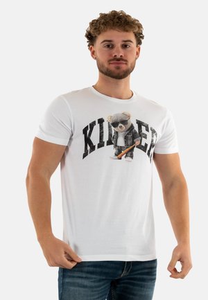 T-shirt en coton blanc avec un imprimé graphique représentant un ours portant des lunettes de soleil et une veste, avec le mot "KILLER" en lettres noires, en gras.