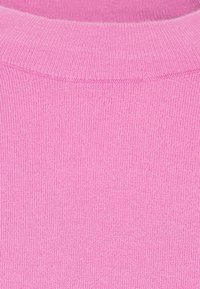 Rosa gestrickter Pulloverstoff mit einer gerippten Textur und einem runden Halsausschnitt. Die Farbe ist einheitlich ohne sichtbare Muster oder Verzierungen.