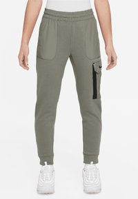 Grå sweatpants med elastisk midja, sidofickor och en cargoficks på höger lår med en svart dragkedja.