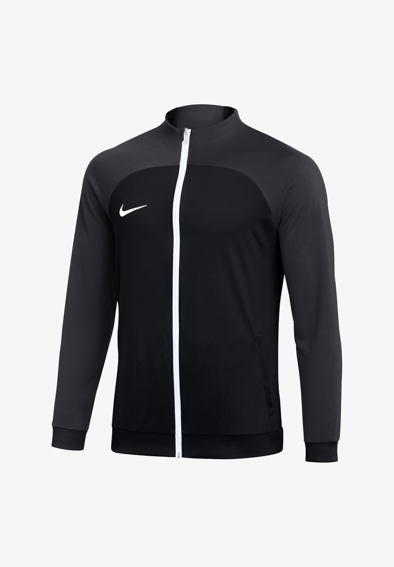 Veste de sport noire et gris foncé zippée avec fermeture éclair blanche et logo Nike blanc sur la poitrine gauche, manches longues et col montant.