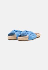 Sandali slip-on a strisce blu con parte superiore in tessuto annodato, suola intermedia in corda di juta e suola piatta in gomma marrone.
