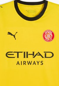 Gul sportstrøje med sorte accenter, præget af Puma-logoet, teksten "ETIHAD AIRWAYS" og et cirkulært Girona Futbol Club-emblem.