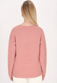 Helles rosa gestricktes Sweatshirt mit Rundhalsausschnitt, überschnittenen Schultern und langen Ärmeln. Weiche Textur mit gerippten Säumen und lässiger Passform.