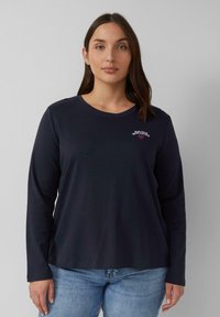 Marinefarbener Langarmshirt aus Baumwolle mit rundem Ausschnitt. Mit einem kleinen bestickten Design mit Text auf der linken Seite.