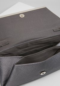 Pochette en tissu gris avec une texture lisse, présentant une finition satinée, une fermeture à pression et des compartiments intérieurs pour l'organisation.