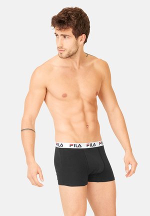 Boxer shorts noirs en coton, avec une taille élastique blanche portant le logo rouge de Fila. Design ajusté et texture lisse.