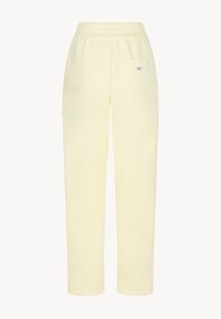 Lichtgele sweatpants met een relaxte pasvorm, elastische tailleband en een enkele achterzak. Gemaakt van zacht materiaal met een gladde textuur.