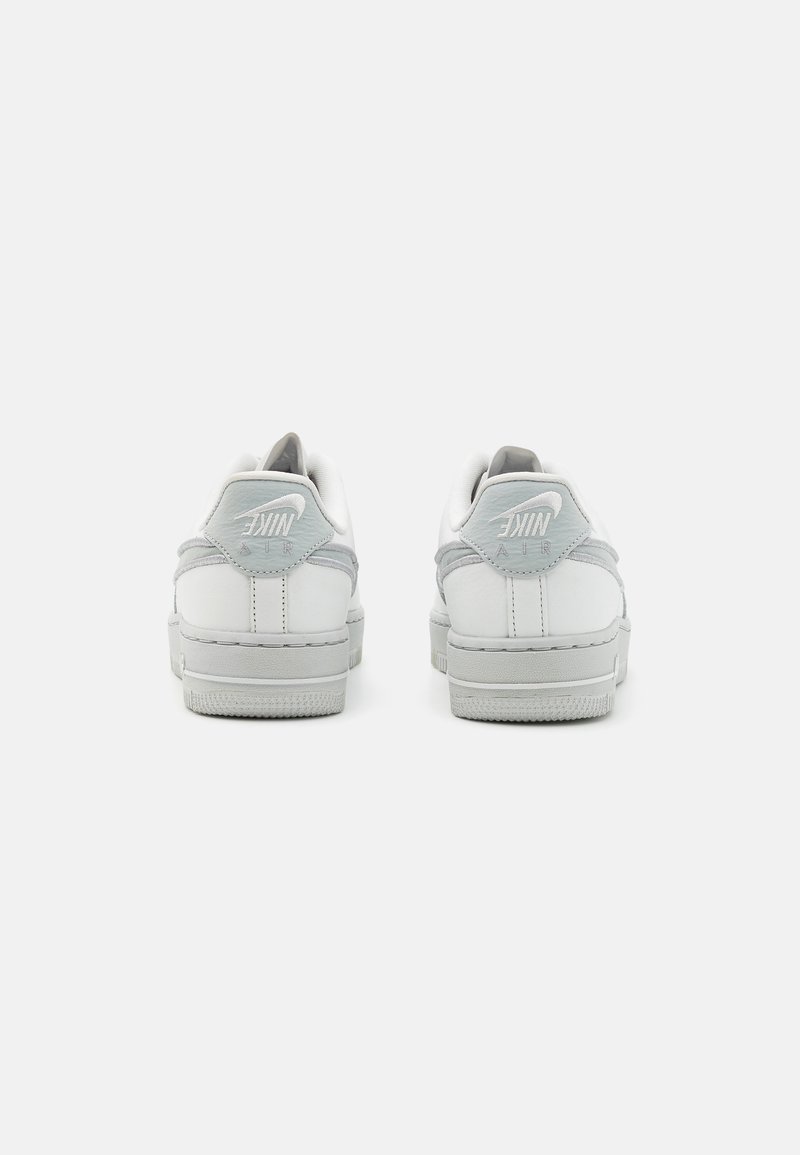Weiße Leder-Sneaker mit grauen Wildlederakzenten, runder Zehenpartie, gepolsterter Kragen und strukturiertem Gummisohle. Mit Nike-Logo auf der Ferse.