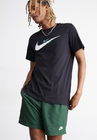 Nike Sportswear FLOW - Pantaloni sportivi - fir