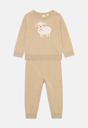 Beige Zweiteiler bestehend aus einem Langarmpullover mit Schafdesign und Knopfdetails, kombiniert mit passenden Leggings. Weiche Stricktextur.