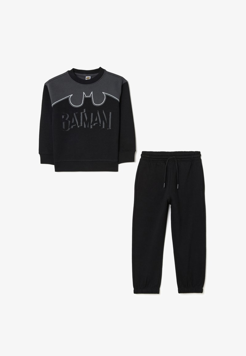 Felpa nera in cotone con logo di Batman, caratterizzata da pannelli grigi e scritte testurizzate; abbinata a pantaloni della tuta neri con polsini elasticizzati.