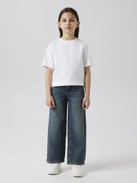 White short-sleeve t-shirt, faded blue wide-leg jeans with frayed hem, and white sneakers. Plain design, no visible patterns or logos.