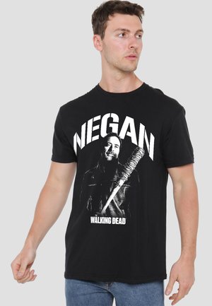 Young man wearing black T-shirt with "NEGAN" text and a graphic of a man holding barbed wire bat from The Walking Dead.