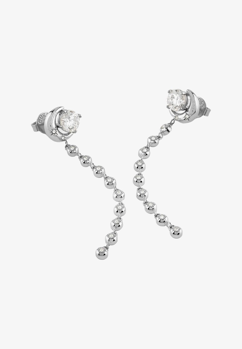 Boucles d'oreilles clous en argent avec des motifs de croissant de lune tenant de grandes pierres claires, reliées à des chaînes pendantes de petites perles polies incrustées de pierres.