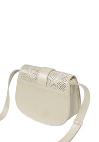 Bolso de hombro de cuero crema con forma redondeada, diseño perforado en la parte delantera y parte trasera lisa. Cuenta con una correa ajustable y una hebilla plana.