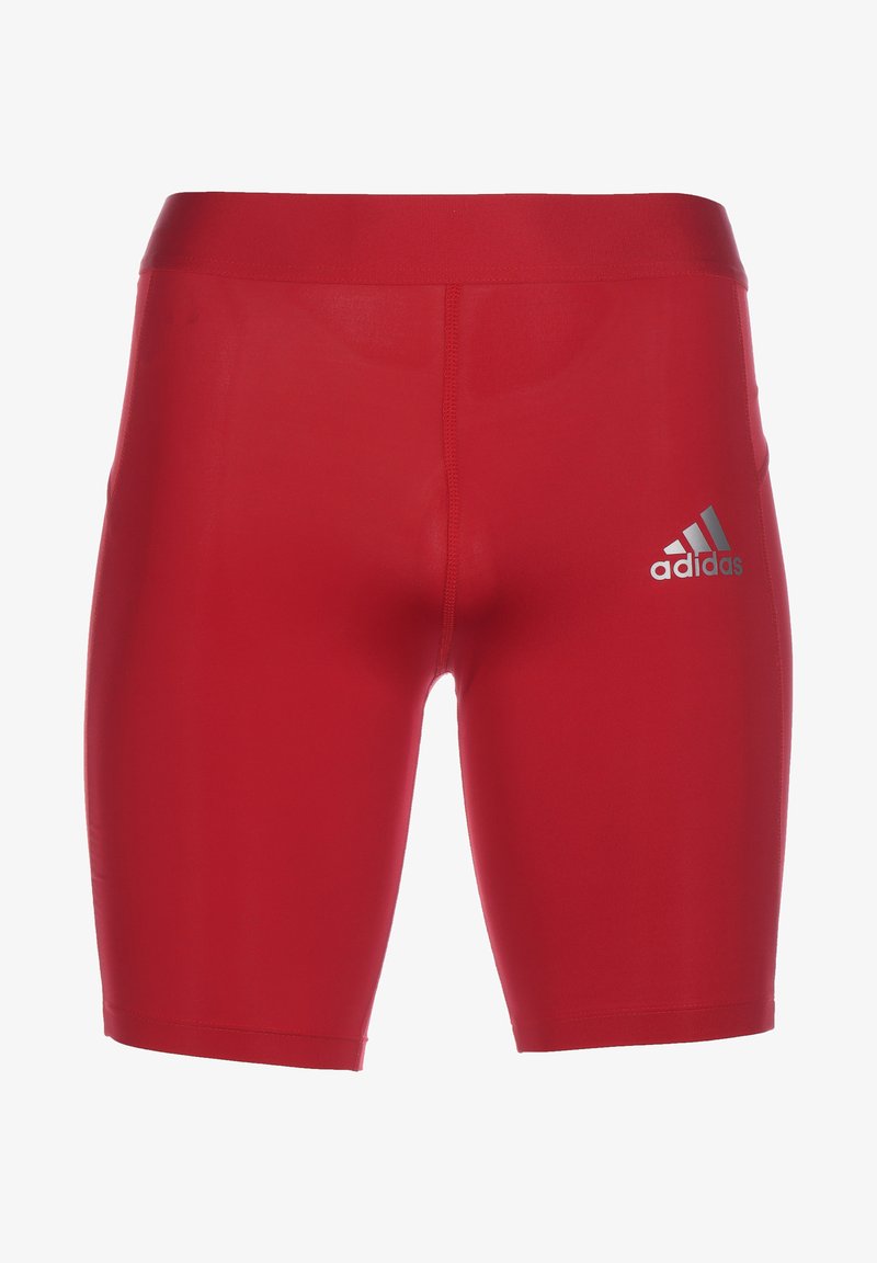 Red athletic shorts with elastic waistband, made from a smooth, stretchy fabric. Features a silver Adidas logo on the left side.
