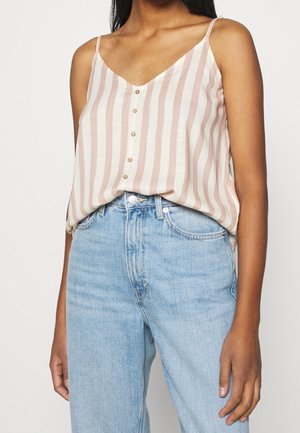 Lichtgewicht top met V-hals en verticale strepen in roze en roomkleur, voorzien van knopen aan de voorkant en dunne bandjes, gecombineerd met lichtblauwe jeans.