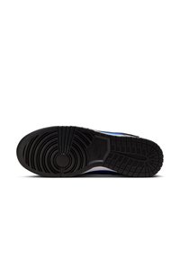 Sole di sneaker Nike con una suola in gomma nera testurizzata, motivi di presa circolari, accenti rialzati e una transizione fluida verso la parte superiore.