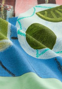 Material cu imprimeuri care prezintă forme abstracte în nuanțe de verde, albastru și alb, cu o textură fină și culori vibrante.