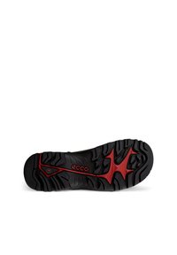 Suola di scarpa in gomma nera con un motivo di battistrada testurizzato, con accenti rossi e un logo centrale. Progettata per offrire trazione e durata.