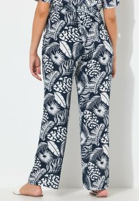 Ensemble de pantalon bleu marine avec des motifs floraux et de feuilles blancs ; coupe ample, taille élastique et jambes larges. Texture de tissu lisse.