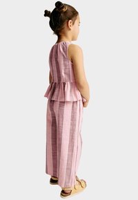 Růžový a šedý pruhovaný dvoudílný outfit s peplum topem a širokými kalhotami. Lehce látkové, s měkkou strukturou a elastickým pasem.