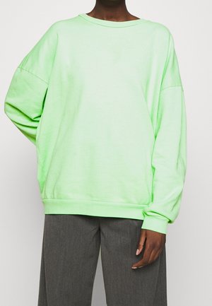 Sweatshirt vert surdimensionné en tissu doux, avec des manches longues et un décolleté large, doté d'un ourlet et de poignets côtelés.