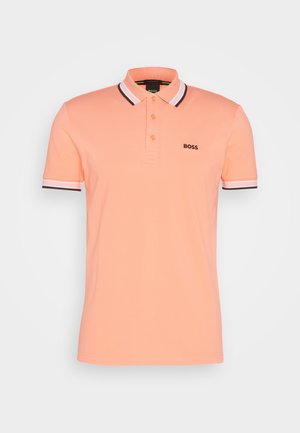 Őszibarack színű pólóing, gallérral, rövid ujjakkal, három gombos záróval és kontrasztos csíkozással az ujjakon. Hímzett logó a mellkason.