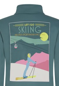 Verbleekte teal sport sweatshirt met een grafische print van een skier, bergen en een kabelbaan. Tekst zegt: "Laten we gaan skiën."